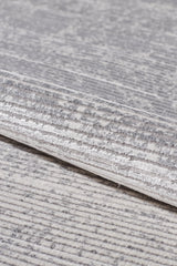 A close-up of the Radient Silver Haze Ombre Rug - M497D shows its soft, minimalist fabric in gray and white with subtle stripes, speckles, and slightly raised textured areas for added interest.