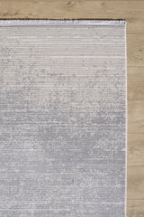 The Radient Silver Haze Ombre Rug - M497D is a rectangular, machine-made rug featuring a gradient from light to dark gray, subtle horizontal lines, and fringe on the top edge, shown on a light wood floor for a minimalist look.