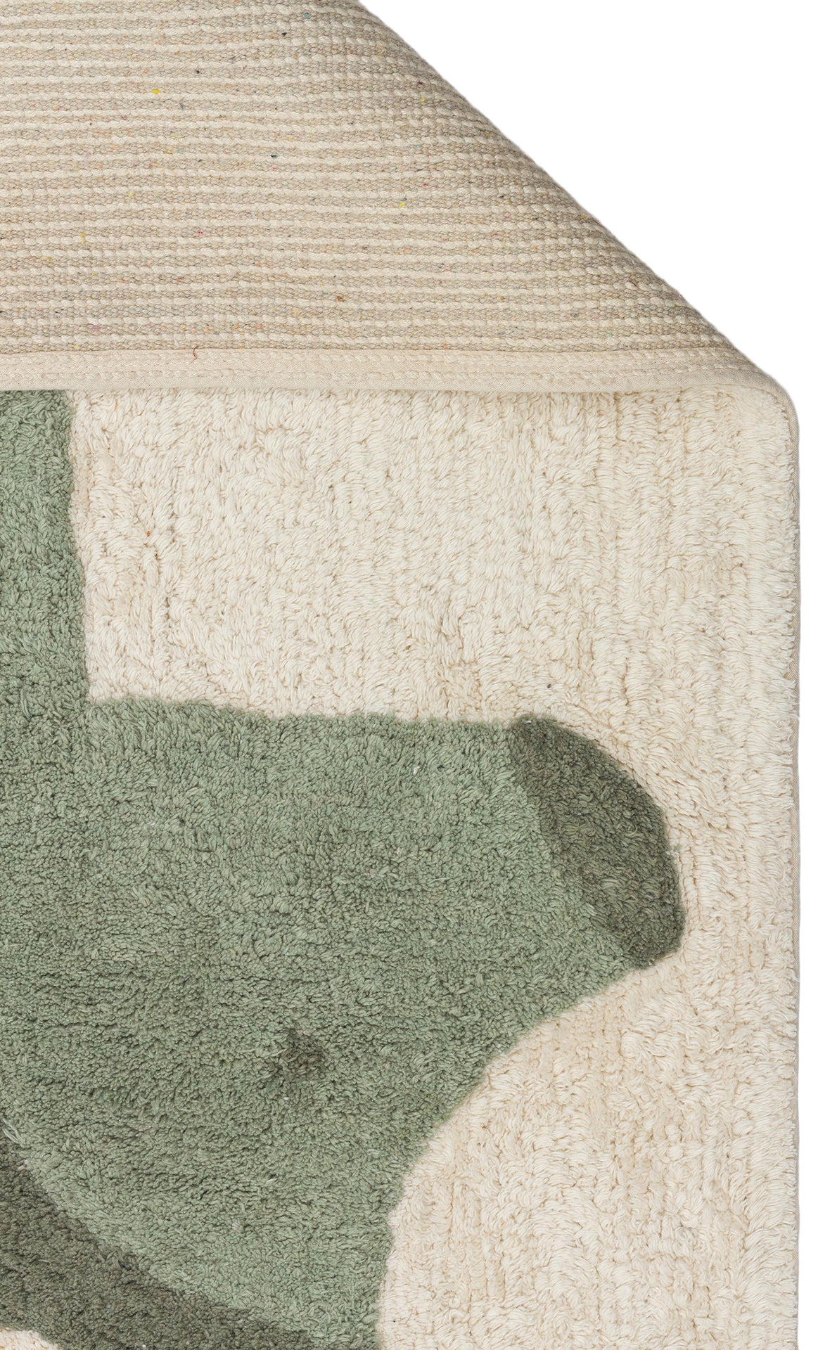 A close-up of the Rainbow Nap - Washable Shaggy - CBN08 kids playroom rug shows its green abstract design on a cream background, with a folded corner exposing the woven underside of this washable shaggy rug.