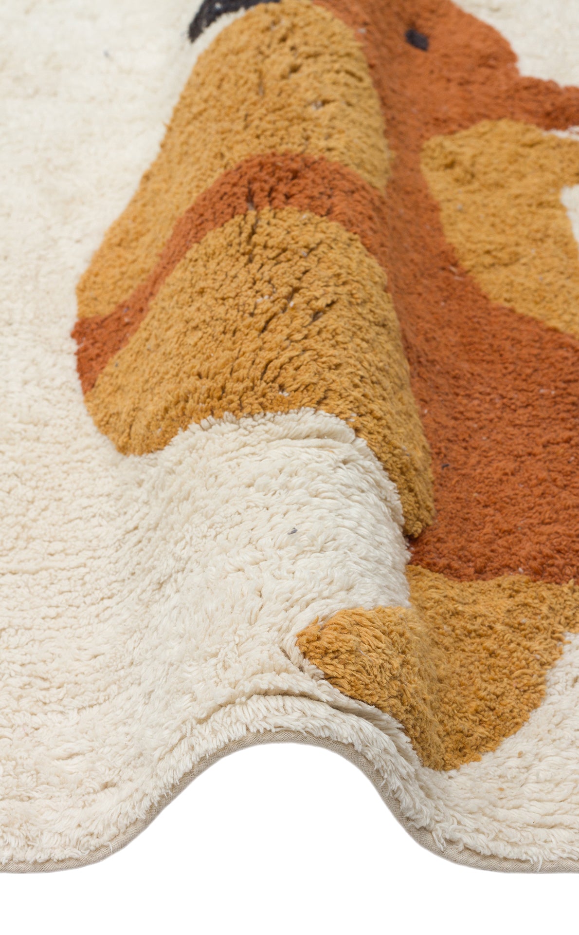 A close-up of the Rainbow Nap - Washable Shaggy - CBN08 rug showcases its cream-colored, washable shaggy texture with raised brown, mustard yellow, and rust sections forming an abstract pattern. The cozy kids' playroom rug edge is slightly wavy.