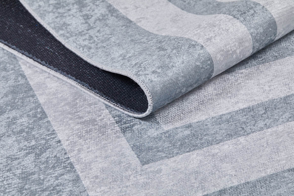 A close-up of the Refined Edge - Washable Rug - JR573 (Custom Size) in textured gray-anthracite, featuring a subtle geometric pattern and contrasting dark backing—ideal for high-traffic areas.