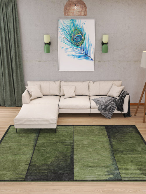 Load image 1 in gallery view. A modern living room with a cream sectional sofa, the Regal Texture - Washable Rug - JRN34 in green tones, green curtains, and a large peacock feather artwork above the sofa. Two green wall sconces and a standing lamp complete this stylish space.