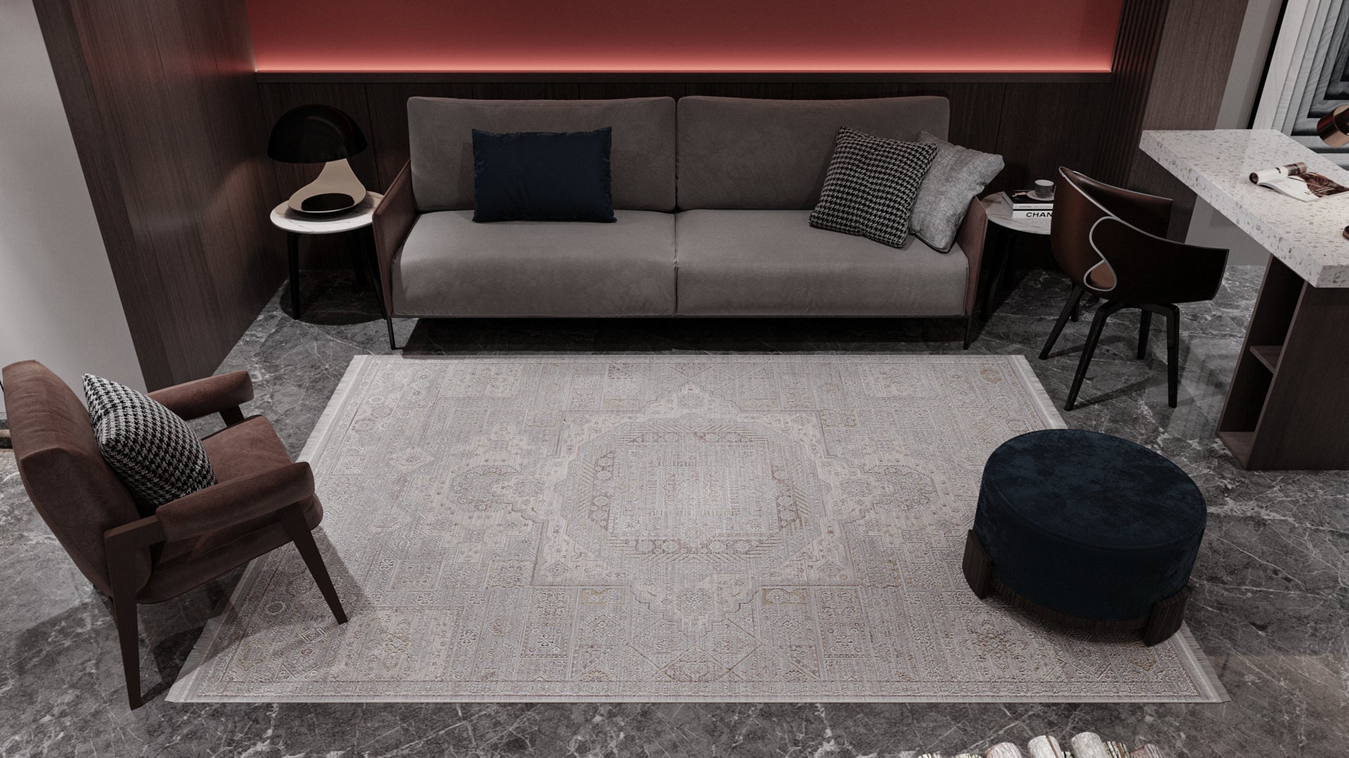 A modern living room with gray marble floors, the Revived Legacy Premium Rug - M616M, a gray sofa with cushions, a brown armchair, a round blue ottoman, and a small black side table against dark wood wall panels and soft lighting.