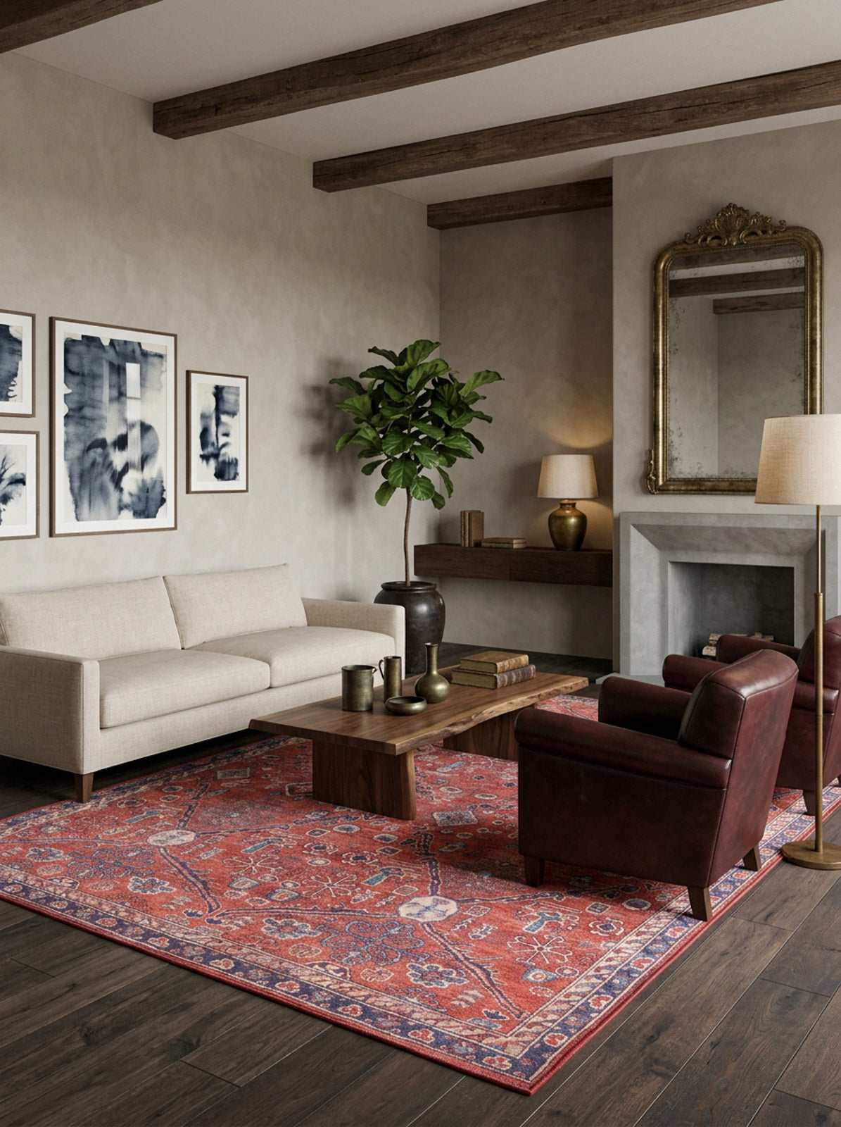 A modern living room with a beige sofa, dark red armchair, wooden coffee table, Rhapsody Authentic Red Washable Rug—ideal for high-traffic areas—potted plant, abstract artwork, gold-framed mirror, and exposed wooden ceiling beams.