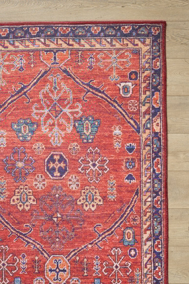 The Rhapsody Authentic Red Washable Rug - LCC3033 (Outlet) US features geometric and floral patterns in red, blue, cream, and orange—ideal for high-traffic areas and stunning on light wood floors.