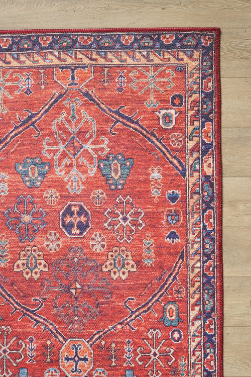 Bild 1 in Galerieansicht laden. The Rhapsody Authentic Red Washable Rug - LCC3033 (Custom Size) features blue, cream, and orange geometric and floral designs with a motif border—perfect for high-traffic areas, shown here on a light wooden floor.