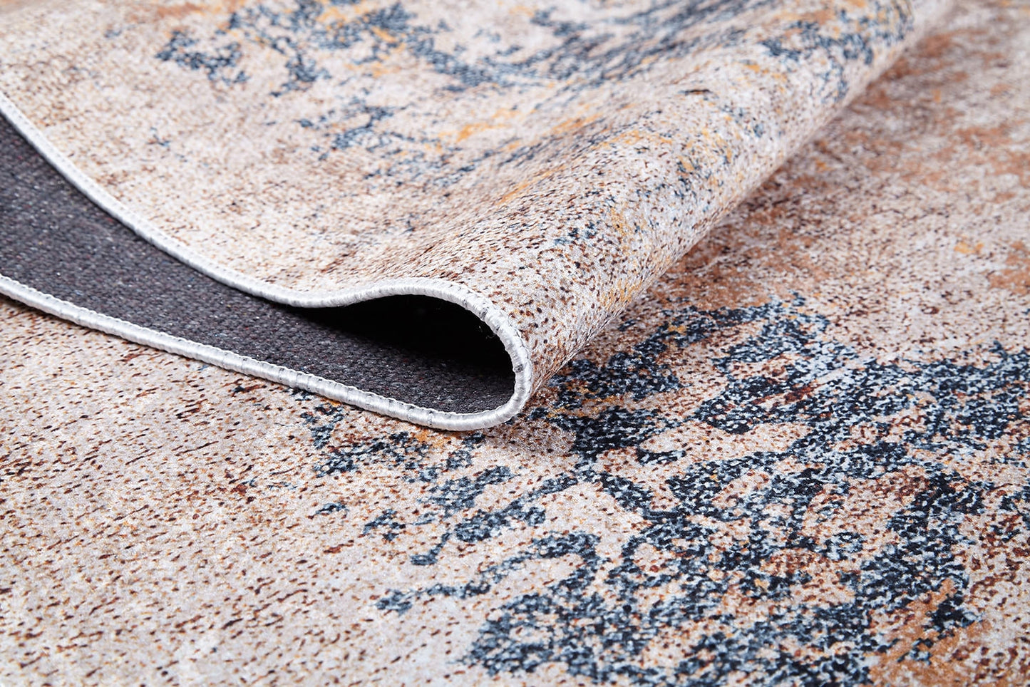 A close-up of the Rhythmic Ripples - Washable Rug - JR1637 (Custom Size) in cream and beige with blue patterns, showing one corner folded to reveal the textured, washable underside.