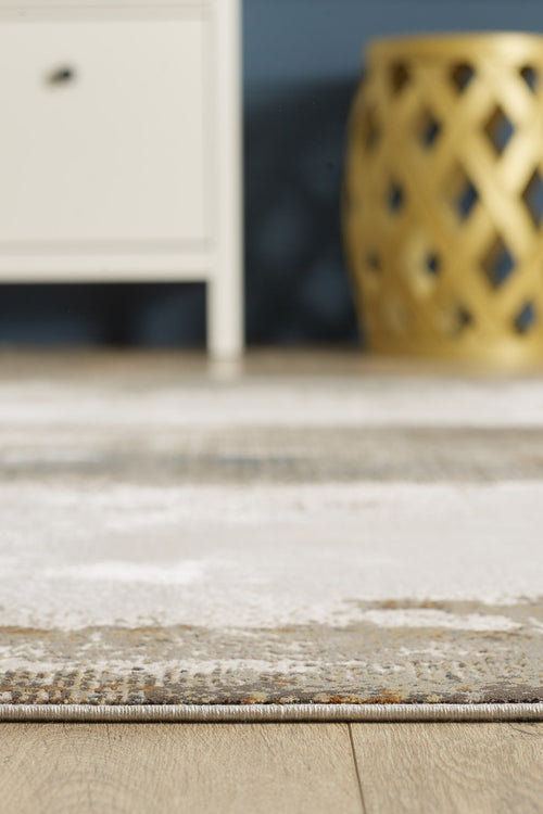 Load image 1 in gallery view. A close-up of the Riverstone Reflections Premium Area Rug - M685L on a wooden floor, with a white cabinet and a yellow stool partially visible in the background.