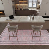A modern kitchen with a marble island, two cushioned barstools, a laptop, potted plants, and neutral-tone cabinets; the floor features the Rose Panel - Washable Rug - JRN1035 (Custom Size) in pink.