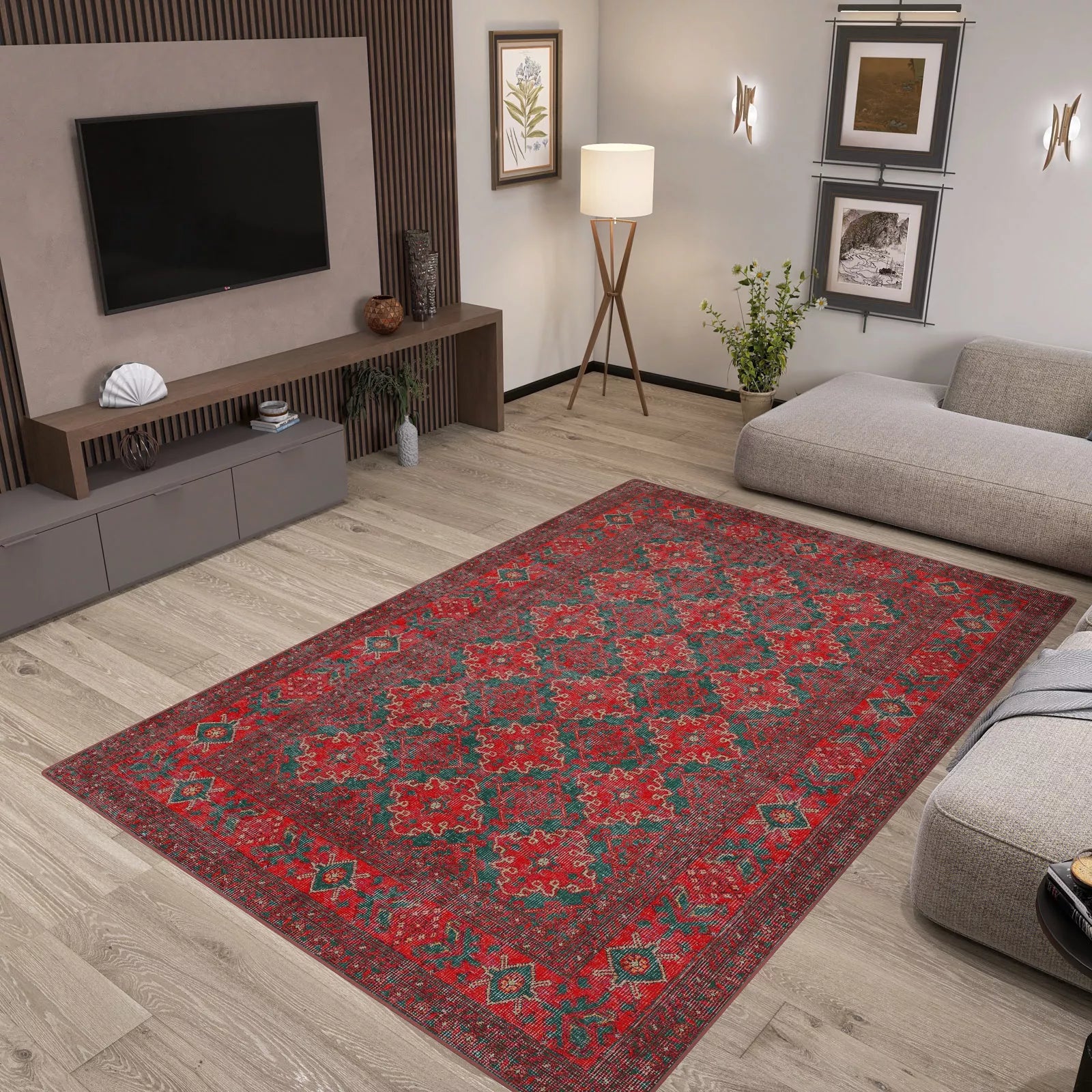 A modern living room with light wood floors, gray furniture, plants, wall art, and a Ruby Medallion - Washable Rug - JRN1031 (Custom Size) featuring a red pattern—ideal for high-traffic areas—centered in the space beneath a sleek media console and TV.