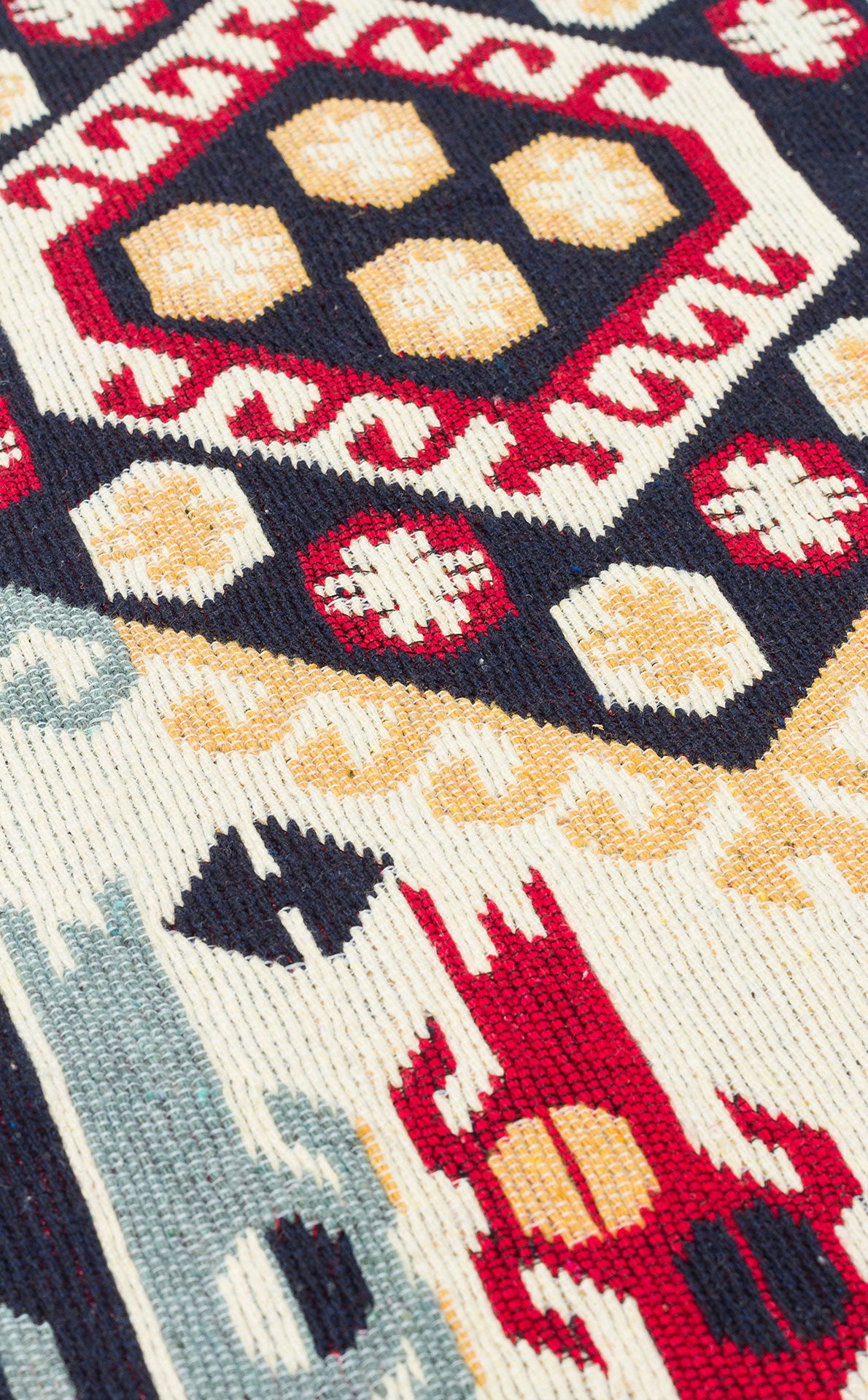 Close-up of the Ruby Weft - Washable Double-Sided Kilims - AR30, a vibrant tribal rug with geometric patterns in red, navy blue, gold, and white, featuring abstract animal and diamond motifs.