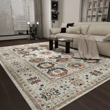 A modern living room with a beige sofa, glass coffee table, and the Rust Mosaic - Washable Rug - JRN1036, showcasing intricate geometric and floral designs in cream, brown, and red. Shelving and large windows complete the scene.