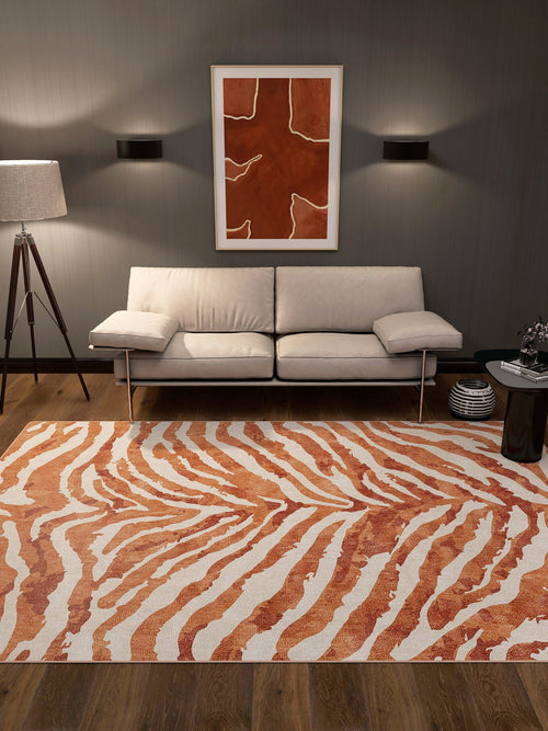 Load image 1 in gallery view. Contemporary living room with a cream sofa, floor lamp, round side table, and the Rustic Mirage - Washable Rug - JRN40 in orange and white zebra-like stripes—perfect for high-traffic areas. An abstract orange artwork hangs above the sofa on a dark gray wall.
