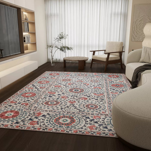 Load image 1 in gallery view. A modern living room with dark wood floors, neutral furniture, the Rustic Pearl - Washable Rug - JRN1030 in red, blue, and cream botanical pattern, a small round table, a plant, and large windows with sheer white curtains.