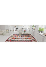 A bright living room with white walls and furniture features the Rustic Refrain - Washable Rug - JR149, green plants on the windowsills, a fireplace in the background, and a cushioned bench with a light throw blanket centered on the rug.