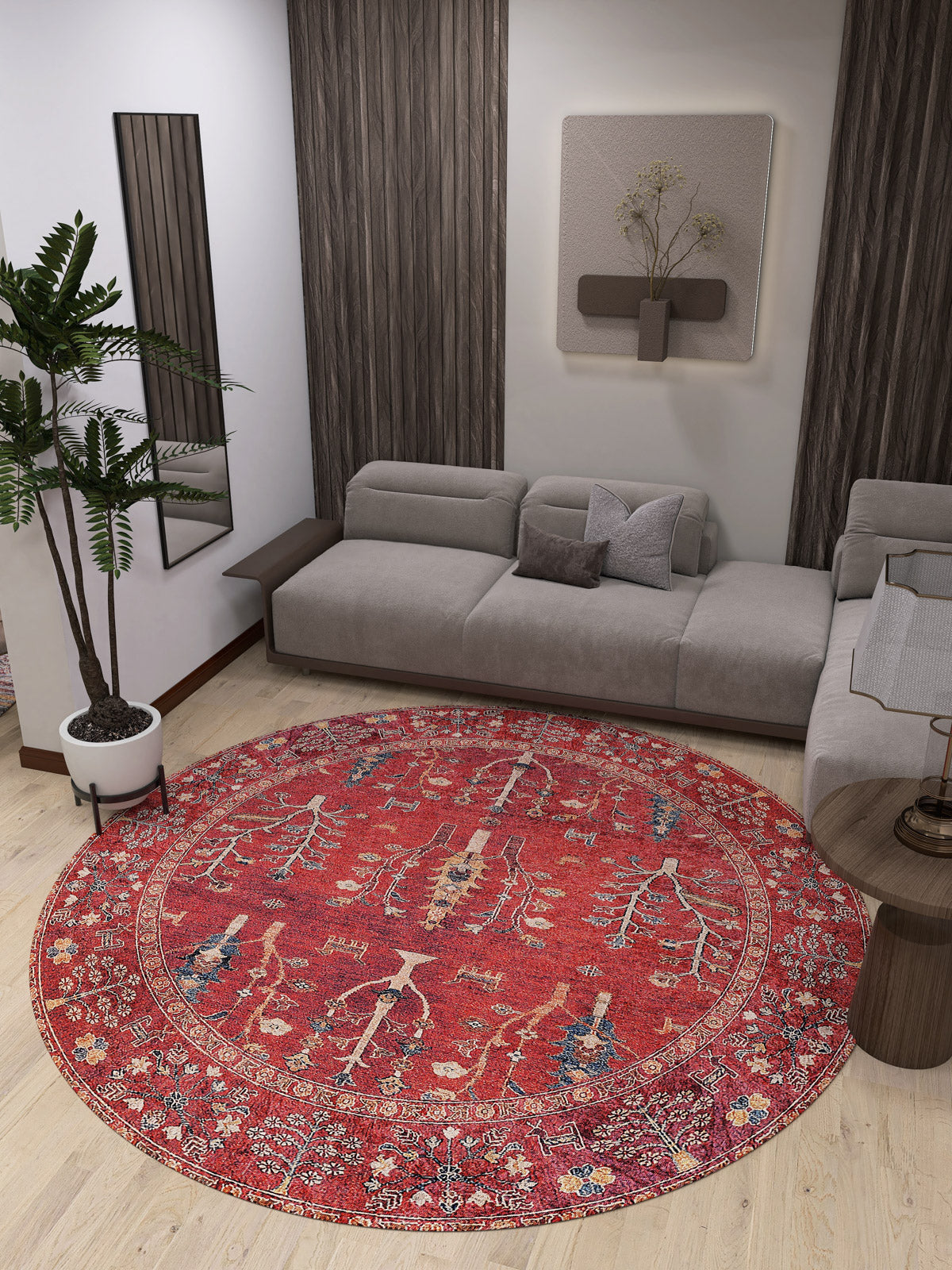 A modern living room with a light gray sectional, the Rustic Retreat - Washable Rug - JR5095 in red for high-traffic wood floors, a tall potted plant, wall mirror, and minimalist art above the sofa.