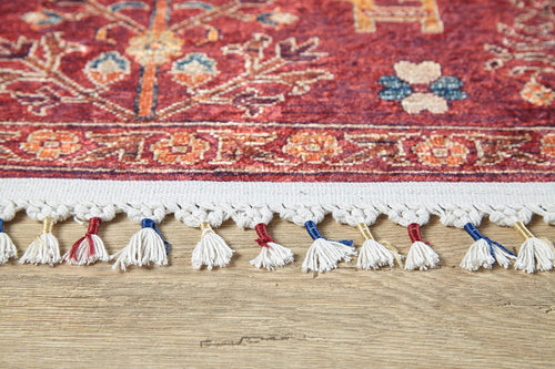 Load image 1 in gallery view. Close-up of the Rustic Retreat - Washable Rug - JR5095 (Custom Size) in red with floral patterns, featuring white fringe and colorful tassels, displayed on a light wood floor—ideal for high-traffic areas.