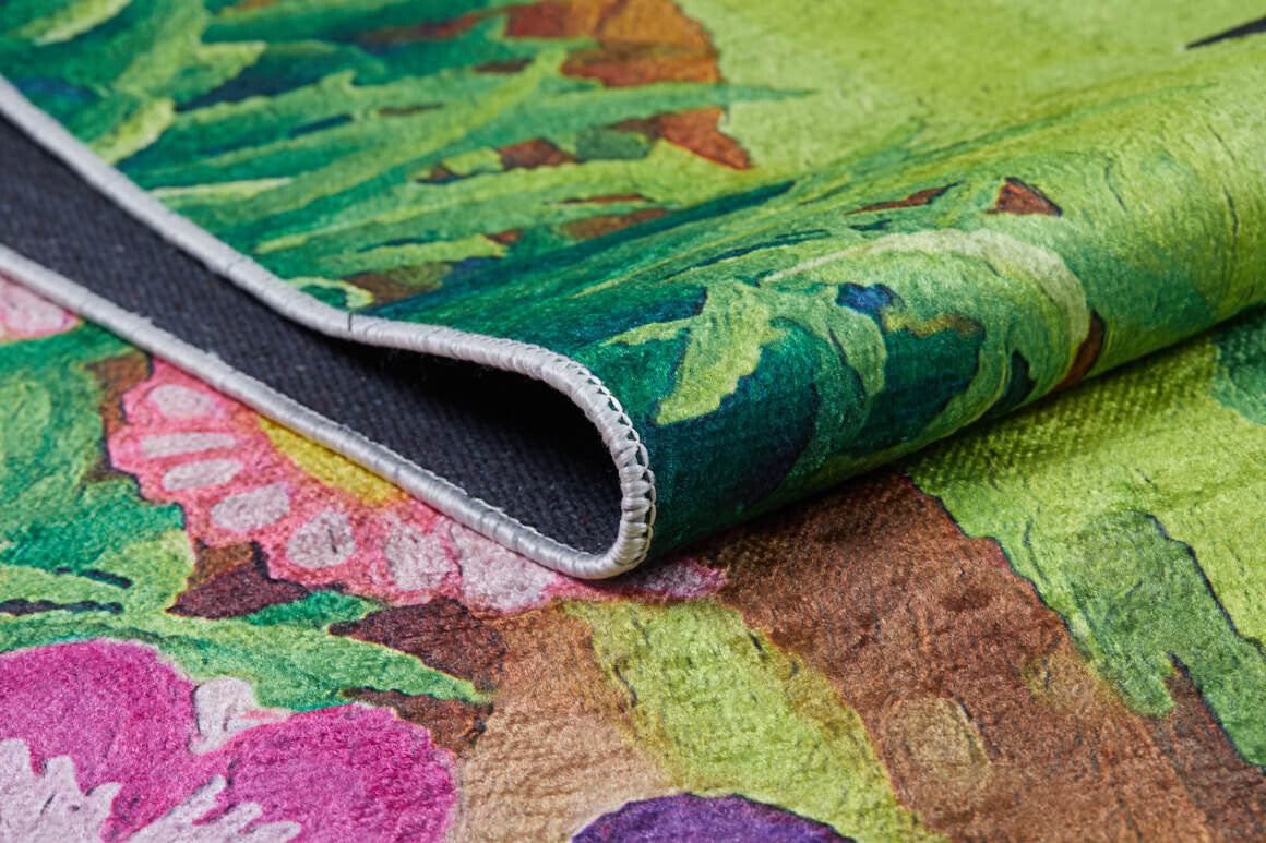 A close-up of the Safari Buddies - Machine-Washable Rug JRC041 (Custom Size), featuring a vibrant multicolor floral and leaf pattern, curled edge revealing black non-slip backing and detailed stitching—ideal for high-traffic areas.