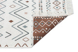 A corner of the Sand Horizon - Washable Double-Sided Kilims - AR05 shows geometric patterns in brown, blue, and beige; one edge is flipped to reveal the darker reverse side and visible fringes.