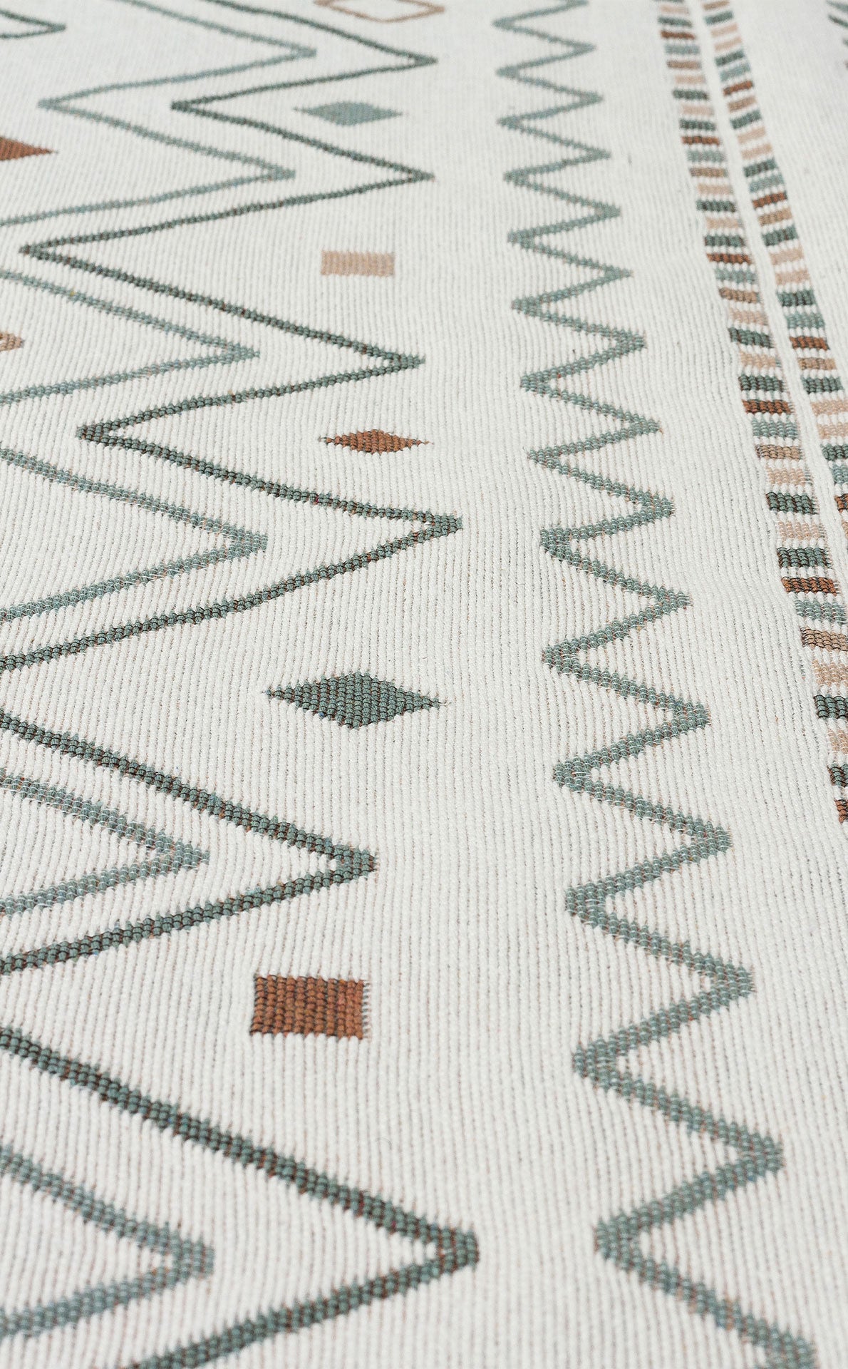 Close-up of Sand Horizon - Washable Double-Sided Kilims (AR05) on a white background, showing green and brown geometric patterns—zigzags, diamonds, and small squares arranged in rows.