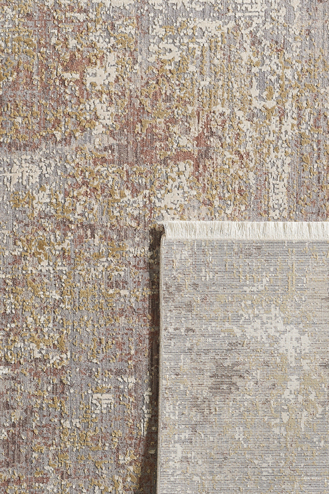 The Sandy Whisper Neutral Rug - M628M is a rectangular, machine-made rug featuring a textured abstract pattern in muted gray, gold, beige, and touches of red. One corner is flipped to show the underside and fringe detailing.