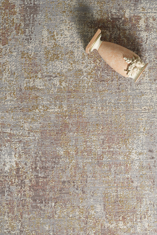 Load image 1 in gallery view. A ceramic vase with decorative details lies sideways on the Sandy Whisper Neutral Rug - M628M, which features a mix of gray, brown, and gold tones atop a textured surface.