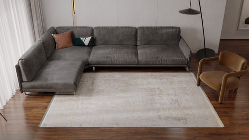 Load image 1 in gallery view. Modern living room with a gray sectional sofa, two decorative pillows, a Sandy Whisper Neutral Rug - M628M on wooden floors, a brown armchair, floor lamp, and sheer curtains covering the window.