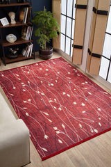 The Secret Garden - Washable Rug - JR1656 features a nature-inspired red, cream, and dark pattern with leaf shapes, shown on a wooden floor near a white sofa—perfect as a washable rug for high-traffic spaces. Custom sizes available.