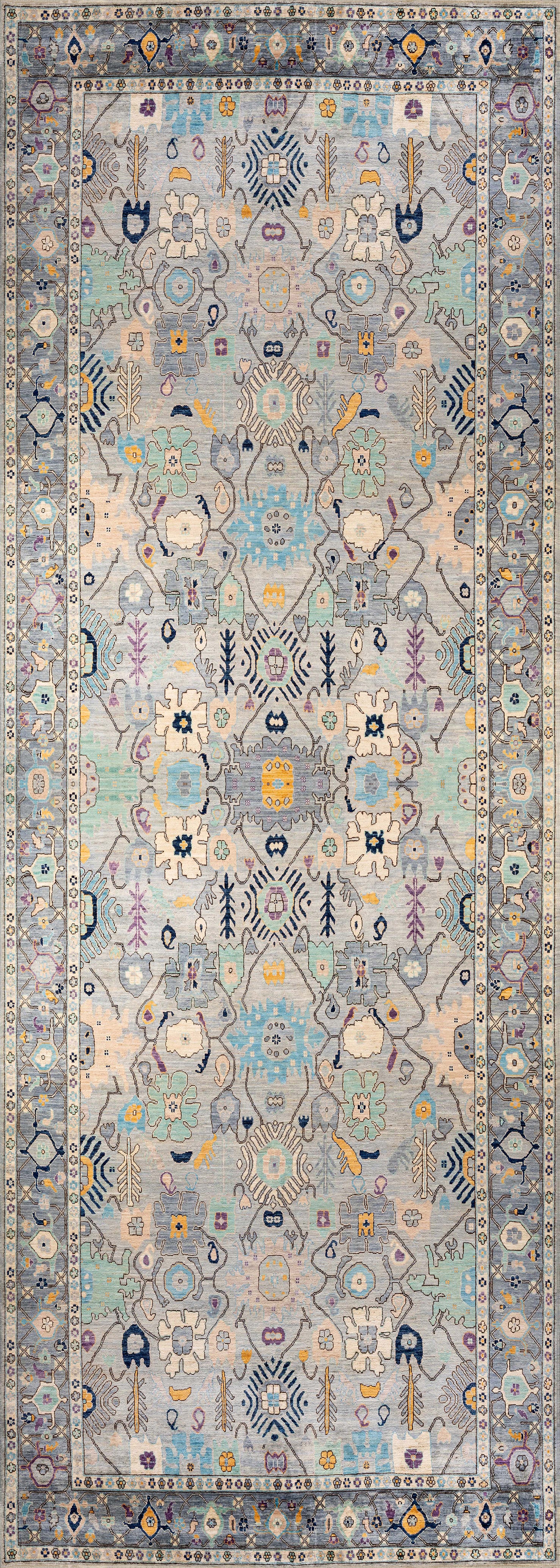 The Seraphix Pastel Bordered Washable Rug - LCC3011 features intricate symmetrical floral and geometric patterns in pastel blue, yellow, and cream with a detailed repeating border, ideal for high-traffic spaces.