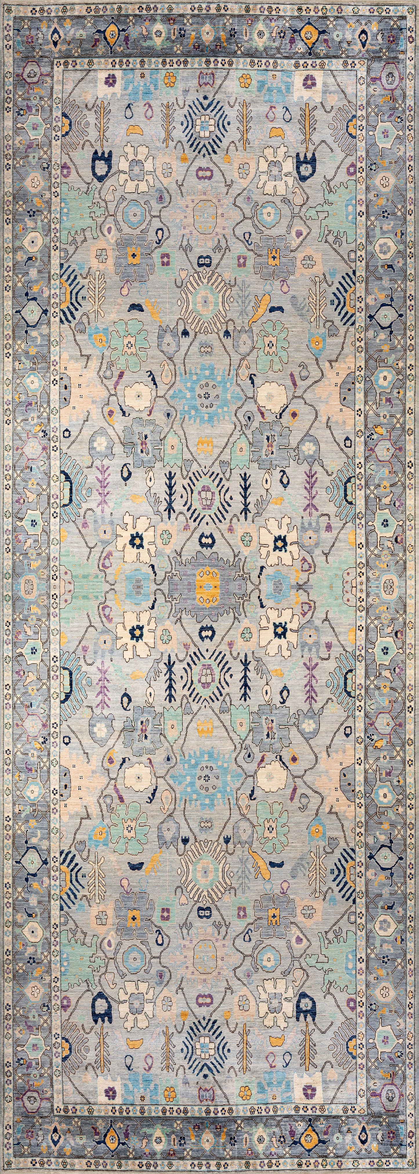 The Seraphix Pastel Bordered Washable Rug - LCC3011 features intricate symmetrical floral and geometric patterns in pastel blue, yellow, and cream with a detailed repeating border, ideal for high-traffic spaces.