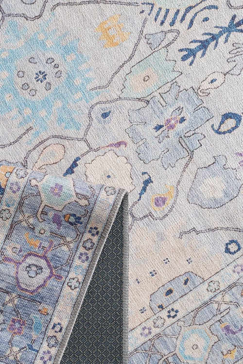 Bild 1 in Galerieansicht laden. A close-up of the Seraphix Pastel Bordered Washable Rug - LCC3011 (Custom Size) shows its blue, beige, and yellow geometric and floral design with a folded corner revealing dark backing—perfect for high-traffic areas.