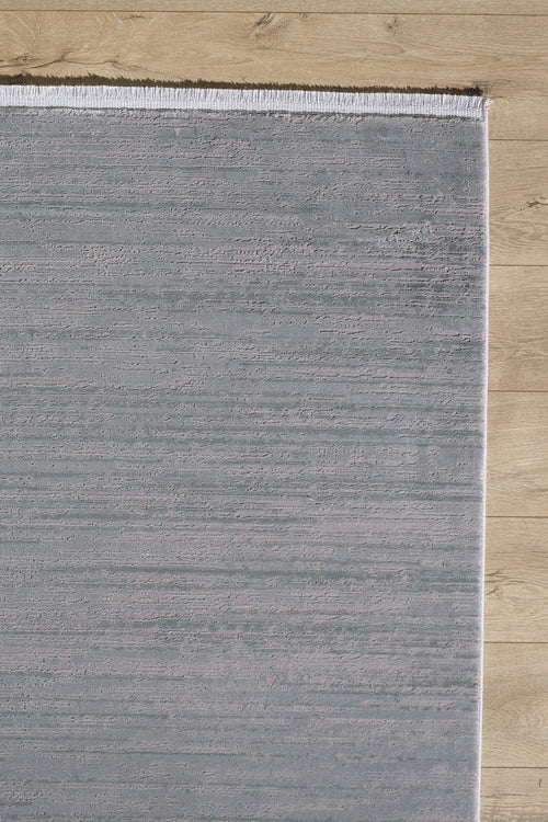 Load image 1 in gallery view. The Silver Lining Grey Rug - M352I is a rectangular, light gray minimalist rug with a flat pile and short white fringe on the top edge, shown partially on a light wood floor with the rest of the floor visible.