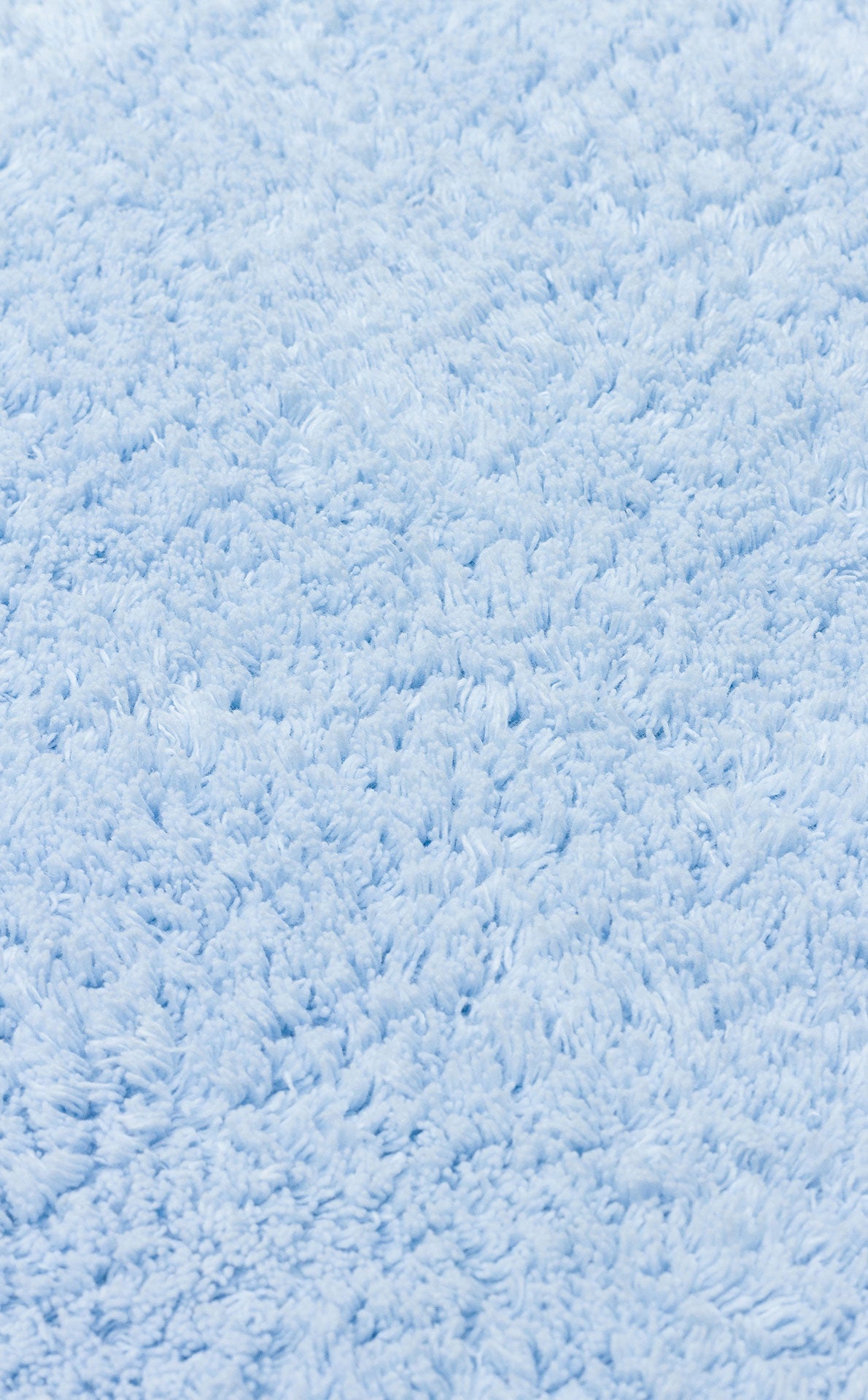 Close-up of the Sky Nap - Washable Shaggy - CBNPLAIN rug in soft blue cotton, featuring thick, textured fibers for a cozy, inviting touch.
