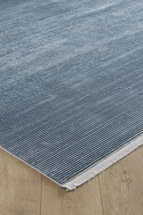 Load image 1 in gallery view. A close-up of the Slate to Midnight Navy Rug - M497M, featuring subtle horizontal lines and white fringe on one edge, displayed on a light wood floor.