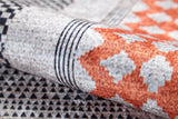 A close-up of the Sleek Design - Washable Rug - JR1727 (Custom Size), showcasing geometric patterns with black and white triangles, orange and gray diamonds, and parallel black lines—perfect for allergy-sensitive homes.