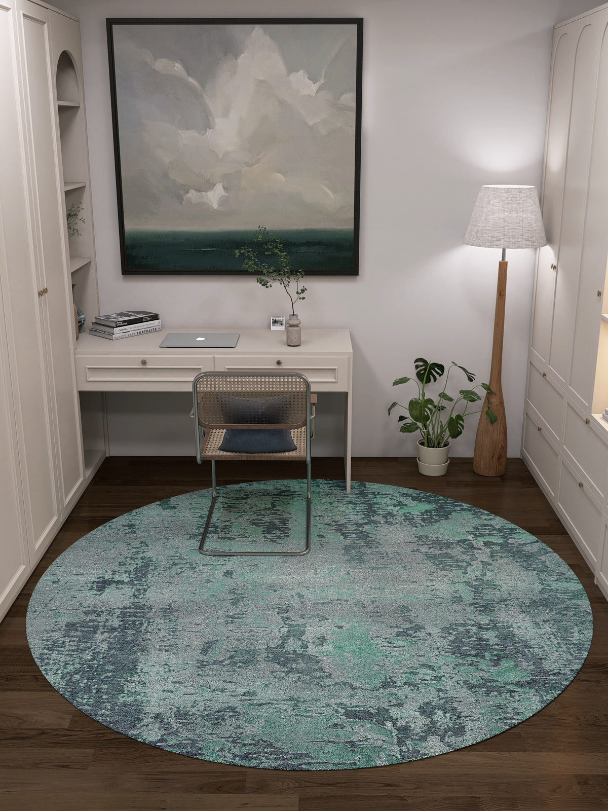 A home office with a white desk, laptop, wicker chair, Smokey Mountains - Washable Rug - JR1631 in green, potted plant, tall floor lamp, bookshelves, and large abstract painting—great for high-traffic areas.