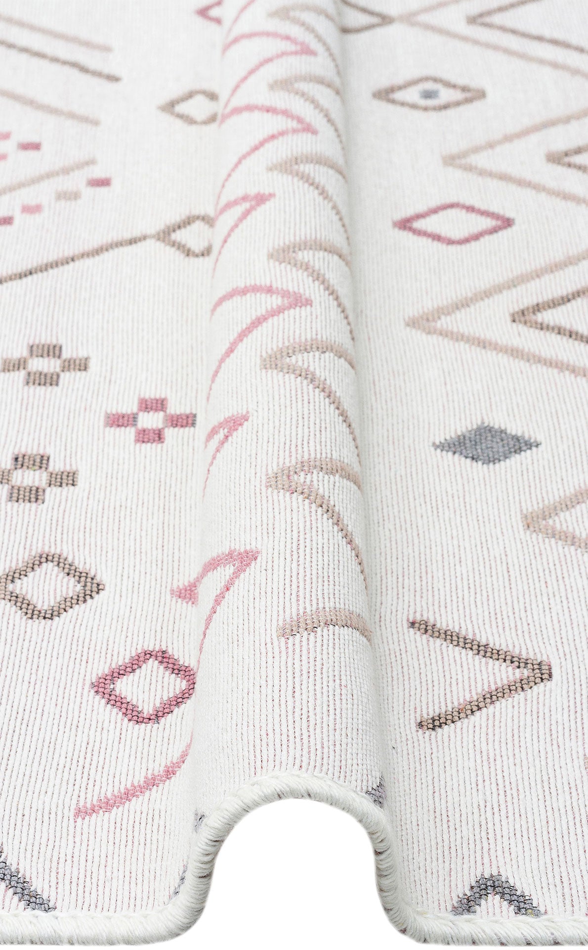 A close-up of the Soft Bloom - Washable Reversible Kilims - AR05 shows a subtle fold and geometric diamond, line, and cross patterns in muted pink, beige, and gray tones.