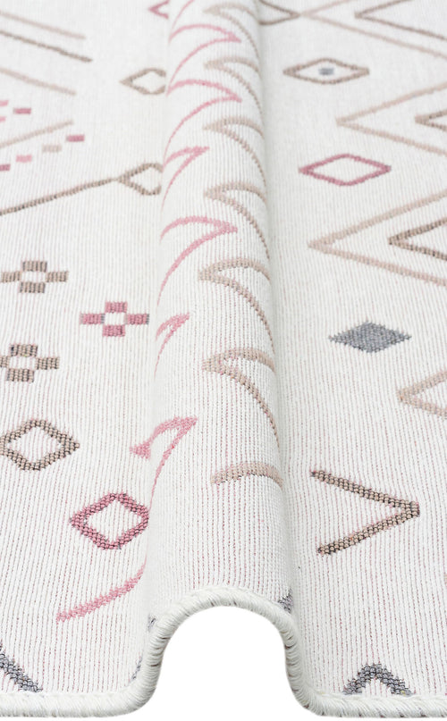 Load image 1 in gallery view. A close-up of the Soft Bloom - Washable Reversible Kilims - AR05 shows a subtle fold and geometric diamond, line, and cross patterns in muted pink, beige, and gray tones.