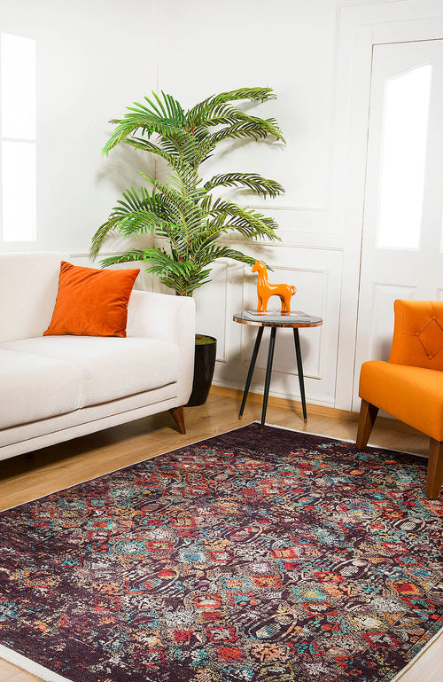 Load image 1 in gallery view. A living room featuring the Soft Haze - Washable Rug - JR1094 (Custom Size) for high-traffic areas, a white sofa with an orange pillow, orange armchair, small round table with an orange horse figurine, potted plant, and white walls.