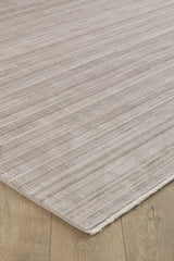 A close-up of the Soft Stripe Serenade Modern Rug - EW2814 in light beige with subtle horizontal stripes on a wooden floor, showcasing its soft, machine-made texture and neutral tones.