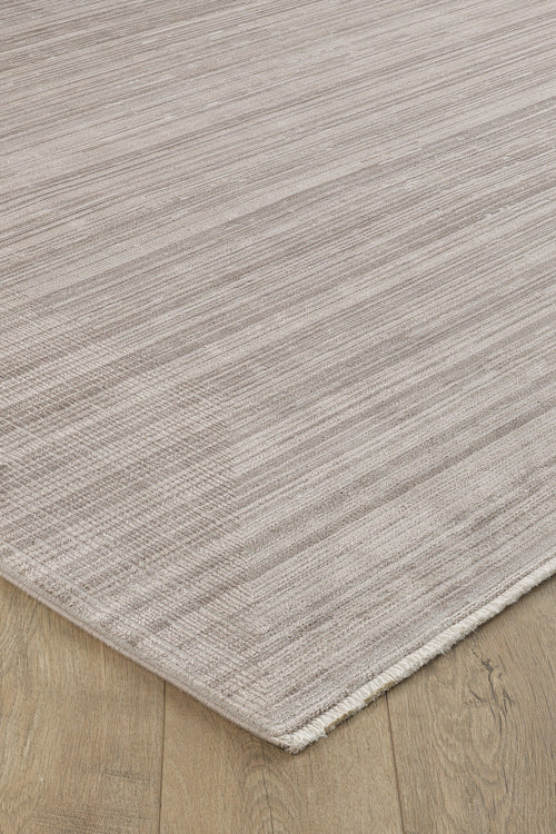 Load image 1 in gallery view. A close-up of the Soft Stripe Serenade Modern Rug - EW2814 in light beige with subtle horizontal stripes on a wooden floor, showcasing its soft, machine-made texture and neutral tones.