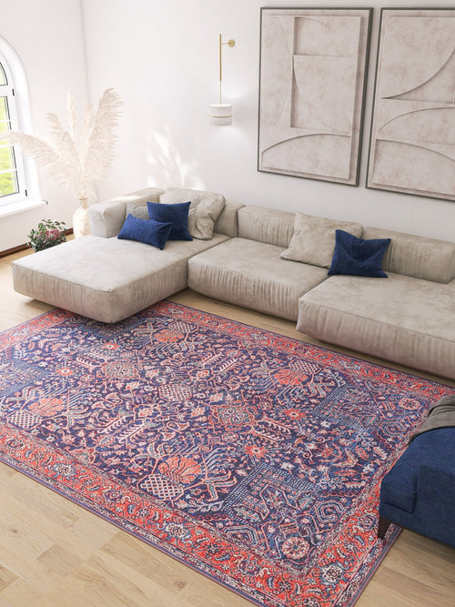Bild 1 in Galerieansicht laden. A modern living room features a large beige sectional, blue accent pillows, abstract wall art, tall white pampas grass, and the Solstice Red Navy Washable Rug - LCC3026 (Custom Size), perfect for high-traffic areas on light wood floors.