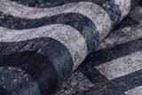 A close-up of the Sophisticated and Chic - Washable Rug - JR1409 (Custom Size) shows its textured black surface with wavy gray stripes—durable for high-traffic areas and easy to maintain thanks to its washable design.