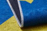 Close-up of the Starry Dreams - Machine-Washable Rug JRC004 (Custom Size), showing its colorful blue, yellow, and black flat weave with white-stitched edges. A lifted corner displays the underside of this washable rug.