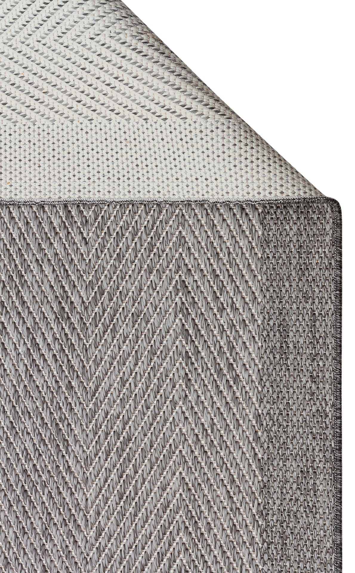 Close-up of Storm Weave - Kilim - MNO02 mattress corner, showing flatwoven polyester fabric in two gray shades—herringbone on the side and lighter woven top—for a modern minimalist look.