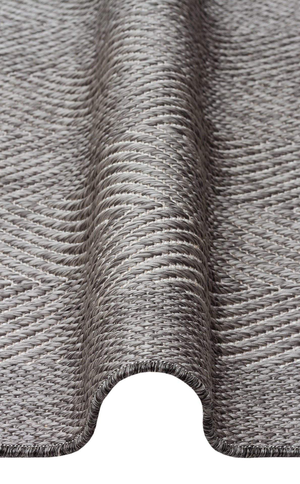 A close-up of Storm Weave - Kilim - MNO02 showcases its gray, textured flatwoven polyester fabric with a smooth, wavy drape that highlights its flexible material and intricate weave—ideal for modern minimalist designs.