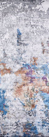 A close-up of the Striking Statements - Washable Rug - JR786 shows gray, white, blue, orange, purple, and green tones in a textured flat weave design, giving any space a modern abstract style with painterly flair.