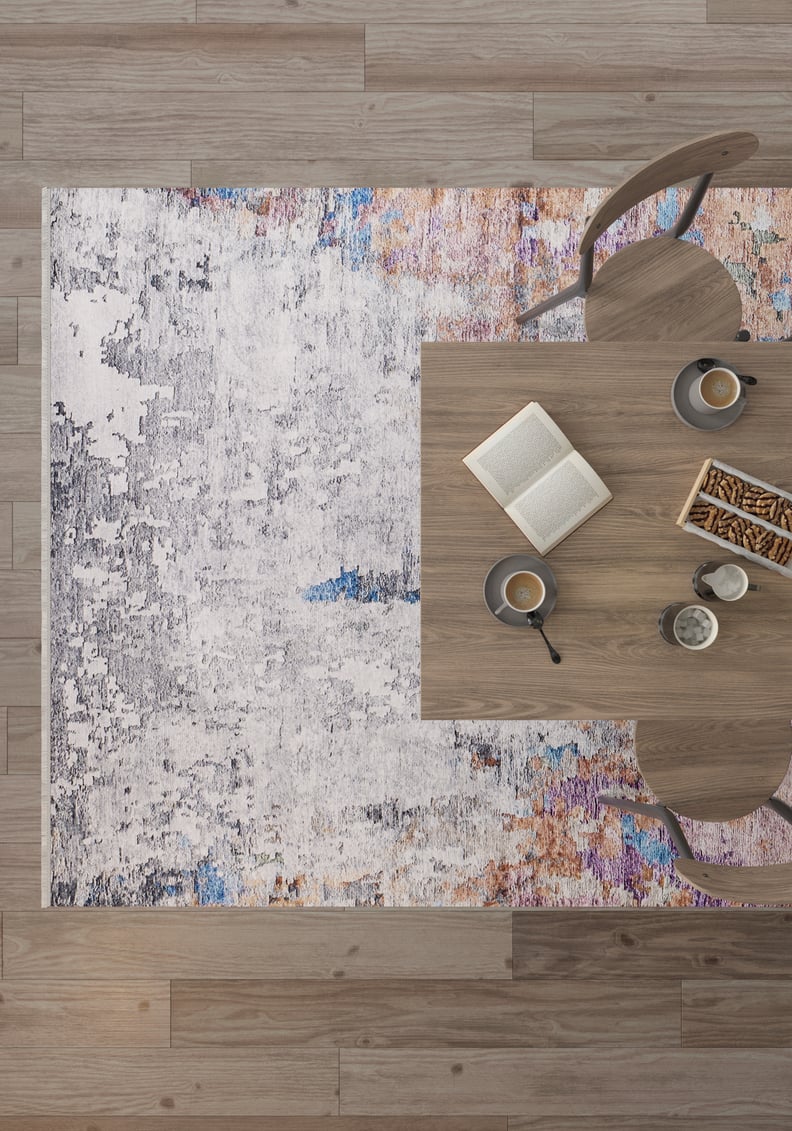Top view of a wooden table with two chairs, coffee cups, an open book, and pastry sticks on the Striking Statements - Washable Rug - JR786 (Custom Size) atop wooden flooring.