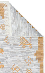 A close-up of the Sunbeam Line - Washable Double-Sided Kilims - AR23 shows a folded corner with white fringes, revealing both sides and a geometric pattern in light gray and mustard yellow.
