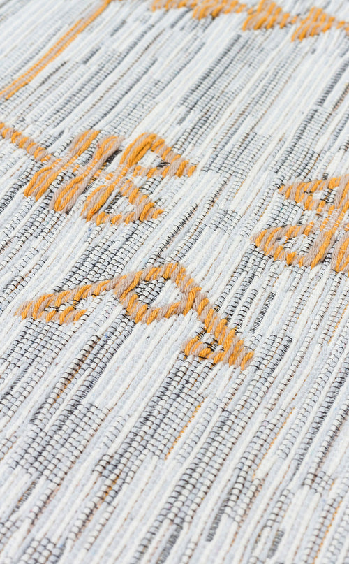 Load image 1 in gallery view. A close-up of the Sunbeam Line AR23 washable double-sided kilim reveals gray and white woven threads accented by orange geometric patterns on its textured surface.